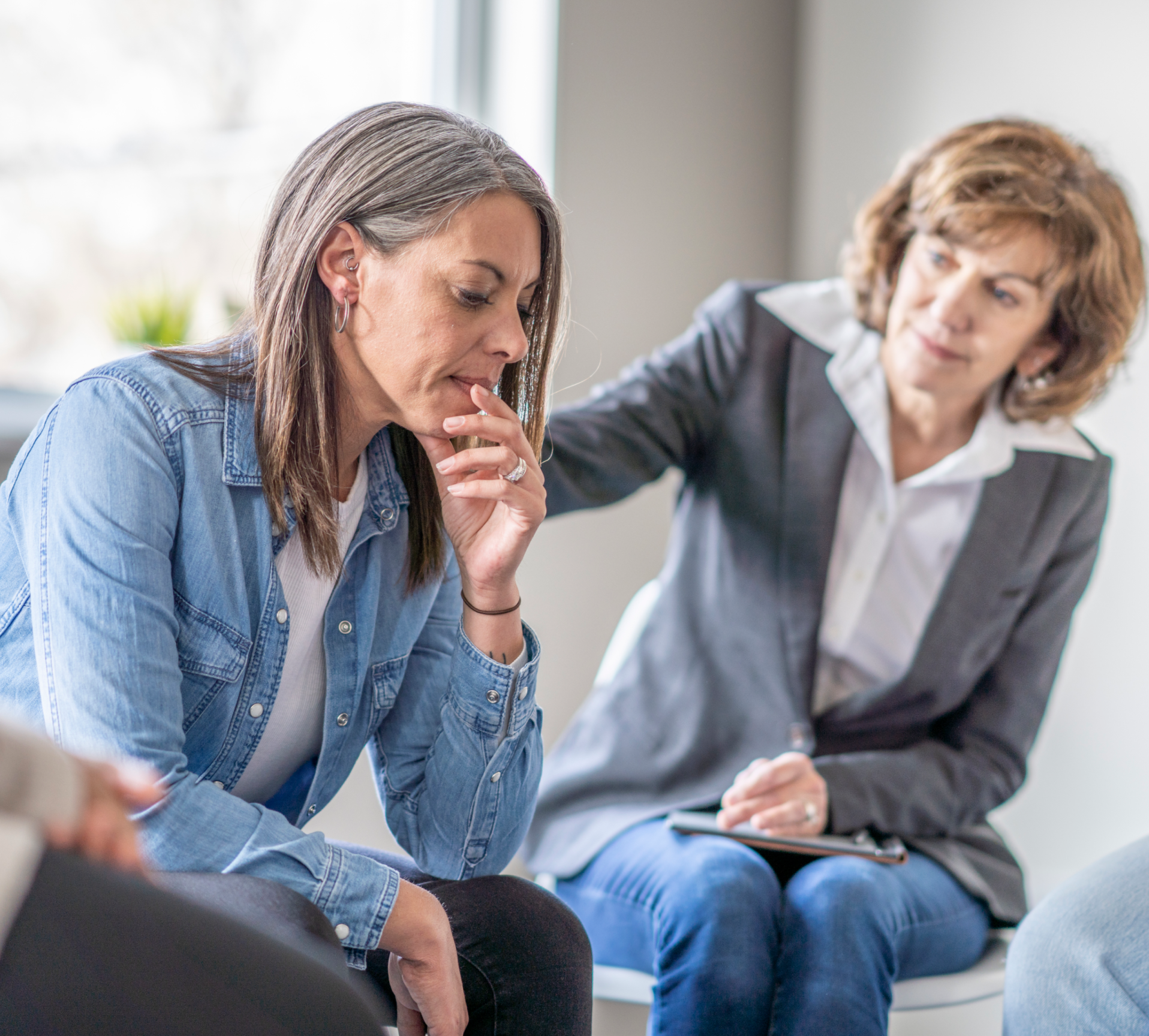 A support group with one woman comforting another woman