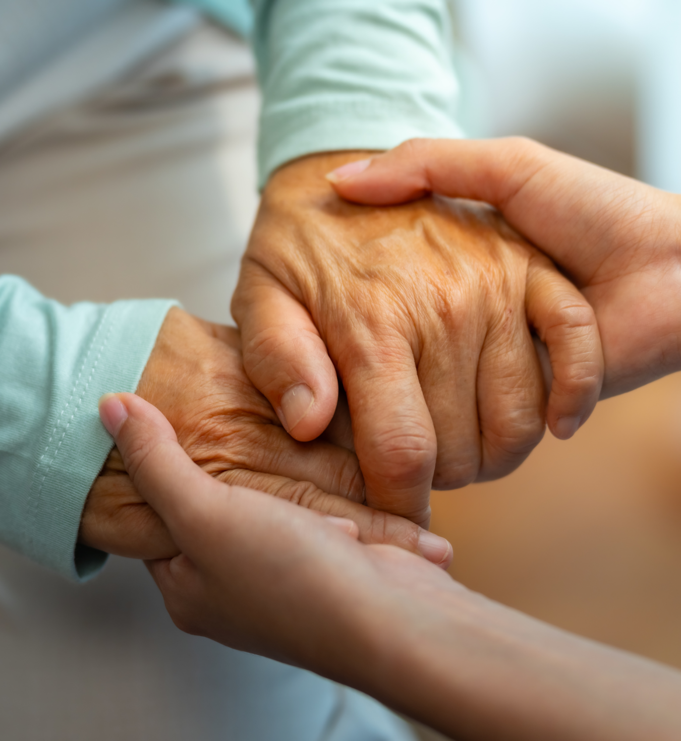 A close up of two sets of hands holding each other