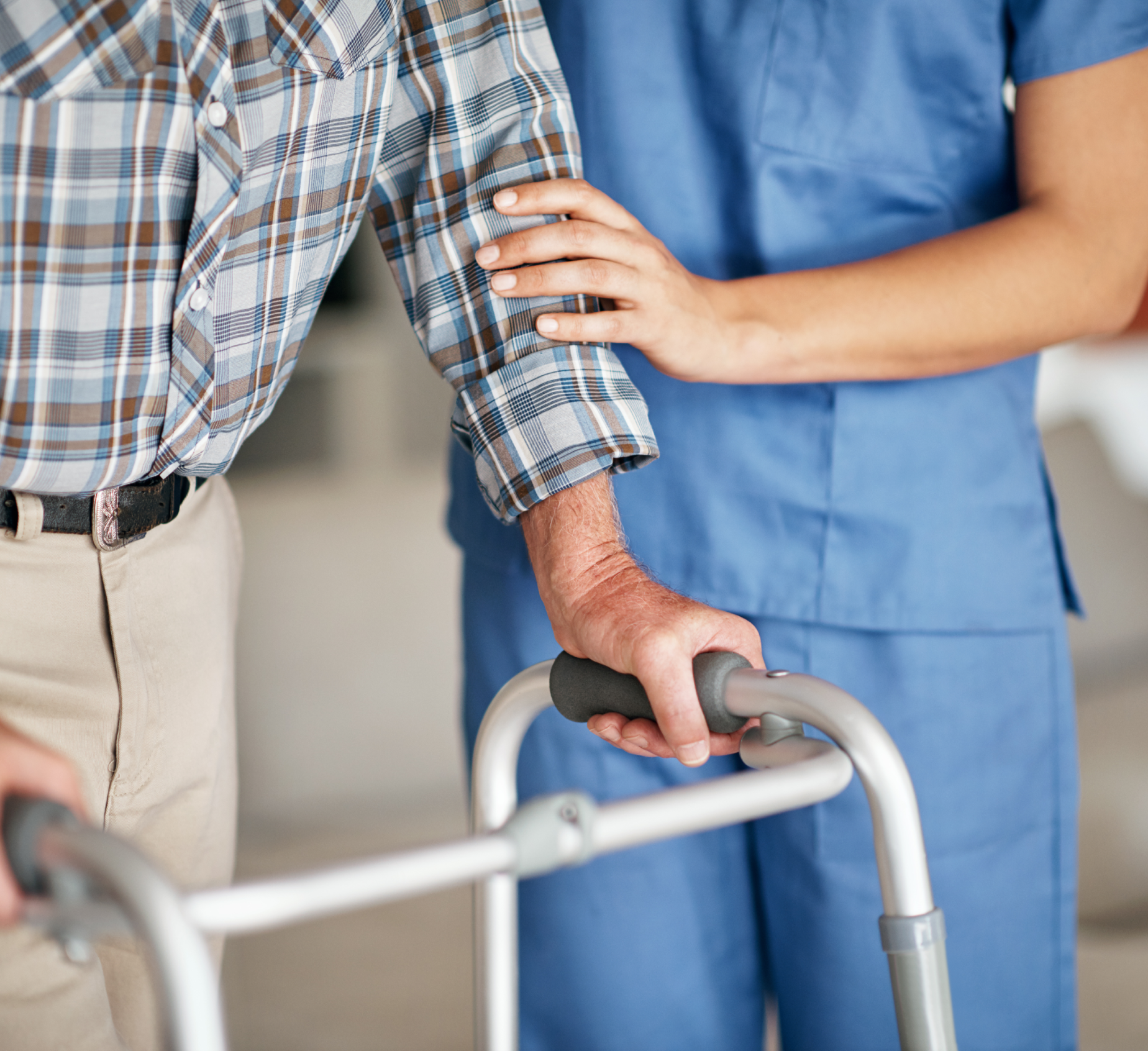 A caregiver helps a man with a walker